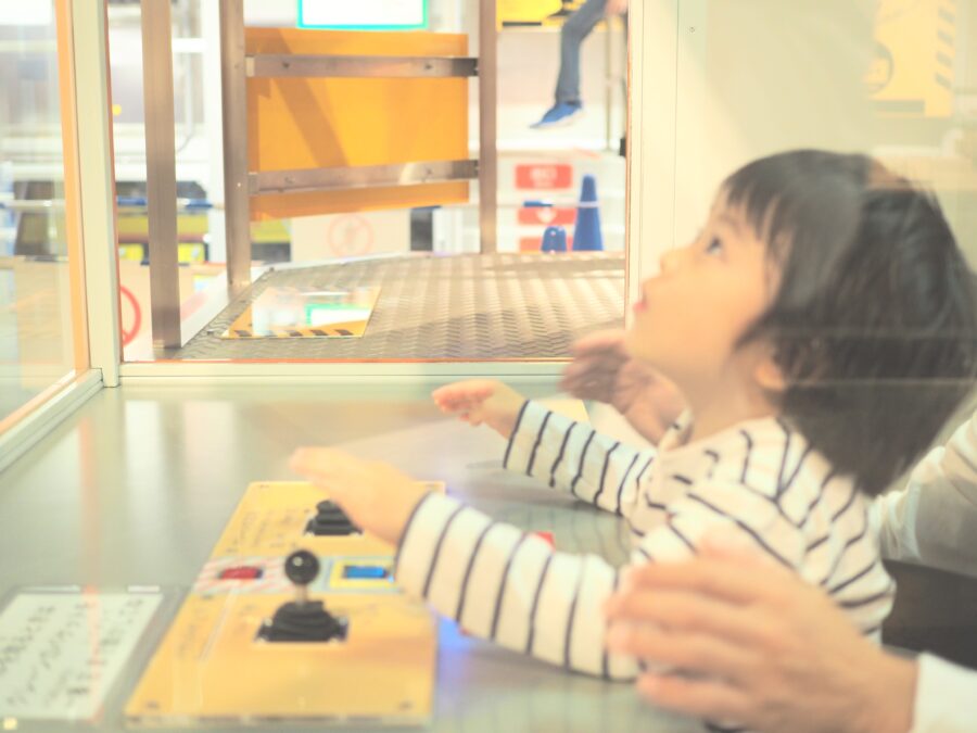 科学技術館の建設館のクレーンの展示物で遊ぶ子ども
